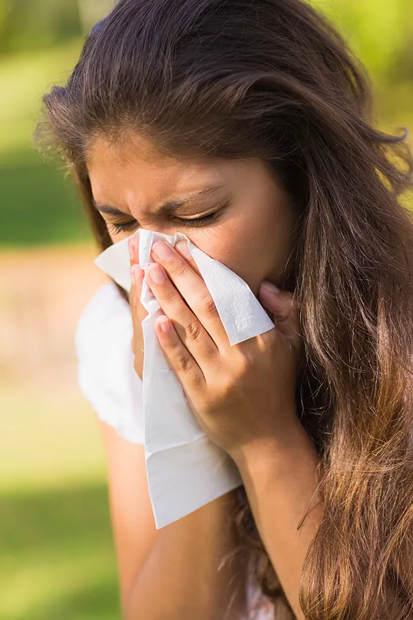 Allergy-Treatment-Treatment A woman outside blowing her nose with a napkin. Get Allergy Treatment from Dr. David Lans in New Rochelle.