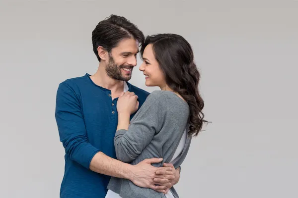 Erectile-Dysfunction-Doctor A man in a blue shirt embracing a woman in a gray shirt smiles due to his successful erectile dysfunction care from Dr. David Lans in New Rochelle.