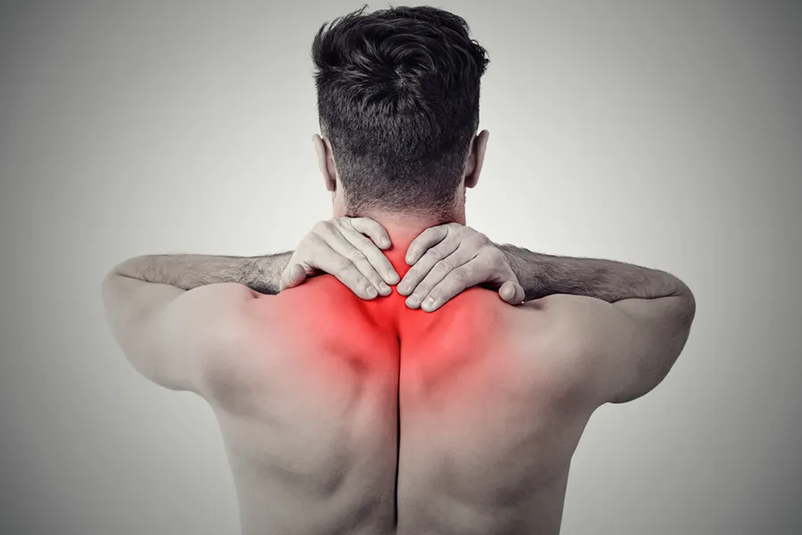 Fibromyalgia-Doctor An image from behind of a man suffering from Fibromyalgia rubbing an area illustrated red with pain in his shoulders and neck . Get fibromyalgia treatment from Dr. David Lans in New Rochelle.