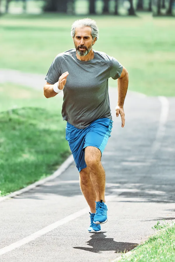 PRP-for-Knee-Injury-Treatment An older man in gym clothes runs on a trail having had successful PRP treatment for knee pain from Dr. David Lans in New Rochelle.
