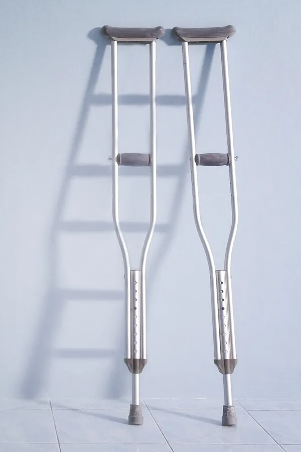 Peptides-for-Healing-and-Recovery-Treatment A pair of crutches rest against a gray wall, representing peptide therapy for healing and recovery from Dr. David Lans in New Rochelle.