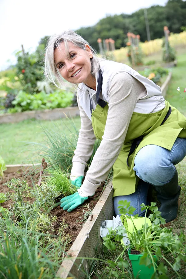 Rheumatoid-Arthritis-Treatment A middle-aged woman smiles while working in her garden. Get Rheumatoid Arthritis treatment from Dr. David Lans in New Rochelle.