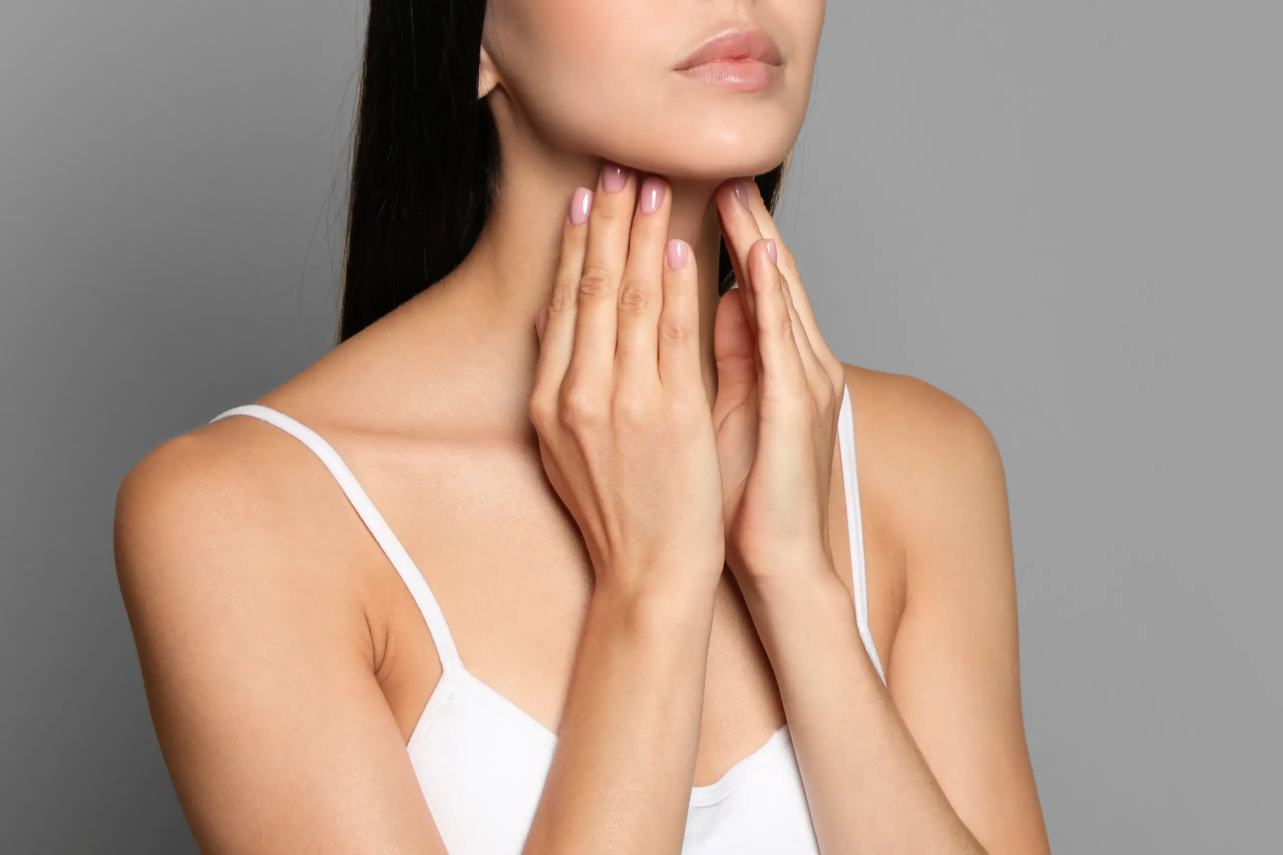 Thyroid-Doctor A woman in a white tank top touches her neck looking for signs of thyroid disorder. Get help for thyroid disorders from Dr. David Lans in New Rochelle.